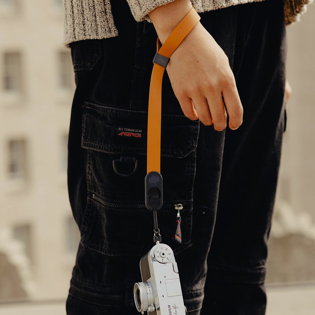 Person wearing a beige sweater with a camera attached to Amber Leather Cuff around their wrist Person wearing a beige sweater with a camera attached to Amber Leather Cuff around their wrist